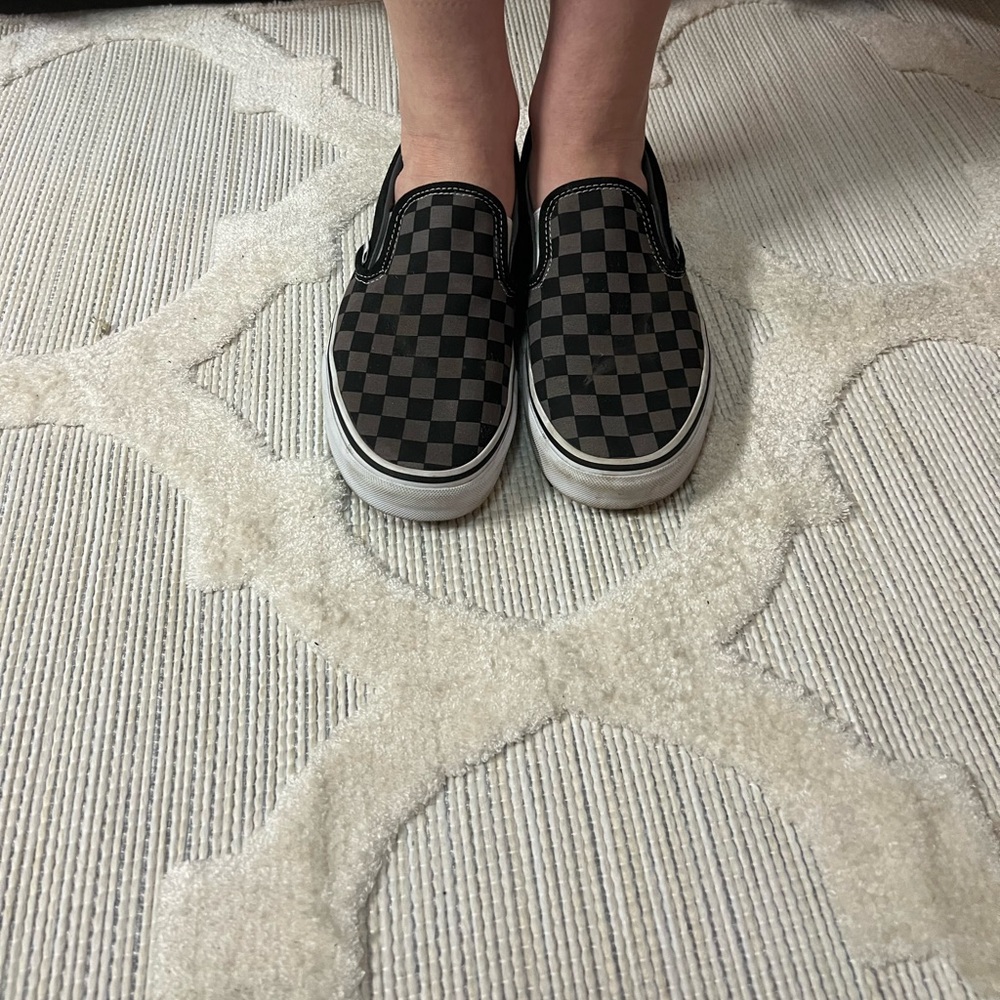 Gray and black checkered Vans tennis shoes
